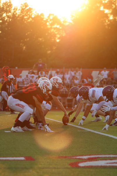 The 2 teams line up on the field to kick off the game.