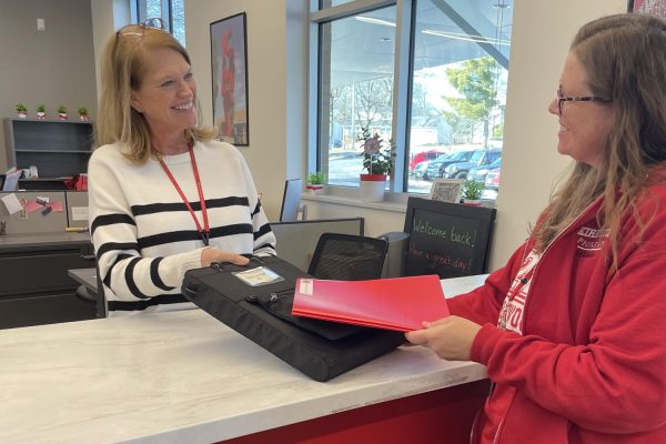 Jordan Wienke and Ellen Kraichely, executive KHS secretaries, re-enact a substitute signing in.